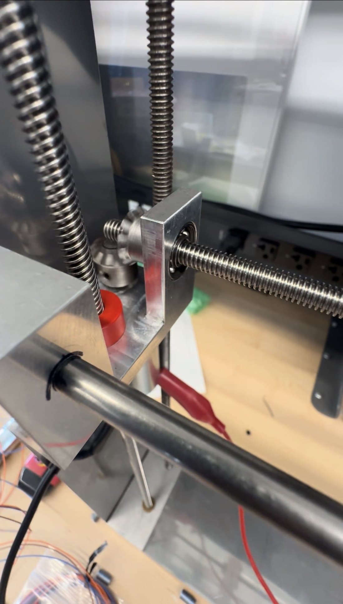 Figure 4: Horizontal drivetrain — motor with miter gears driving the lead-screw track the hot-wire mount rides on.